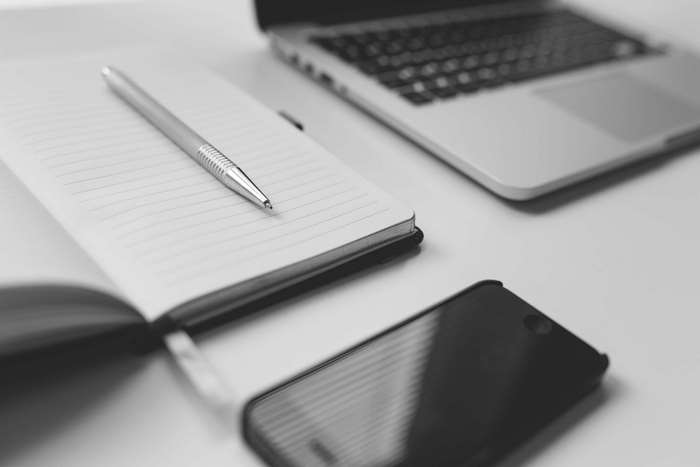 Notebook, Pen, Smartphone, and Laptop on a Desk
