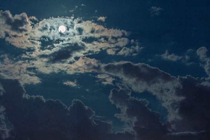 Full moon behind clouds in a night sky