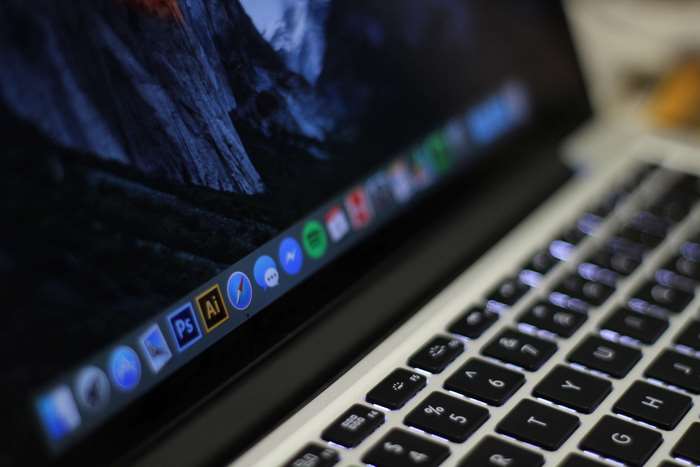 Apple MacBook with Adobe Creative Suite icons