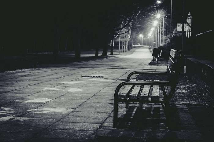 Park bench at night with streetlights