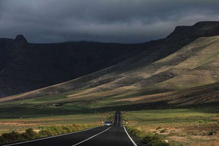 Road through mountains under cloudy sky 4K