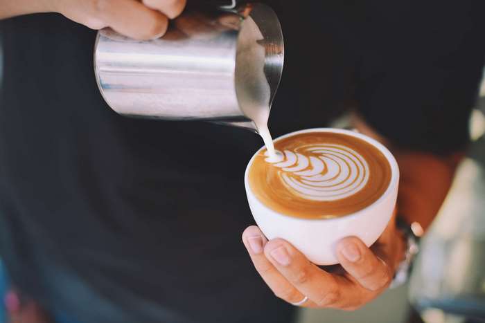 Latte art being poured into a cup of coffee