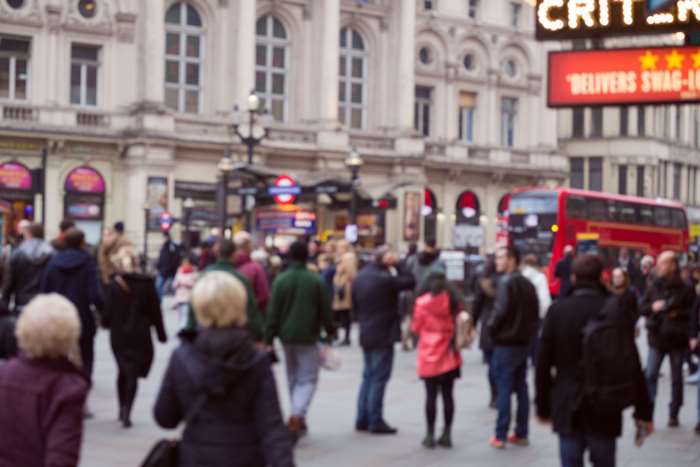 Crowded London street with red bus and buildings