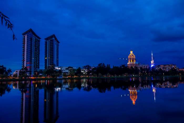 Batumi skyline with buildings and lake reflections at night