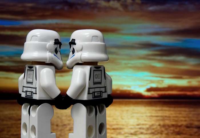 Two Lego Stormtroopers holding hands at sunset