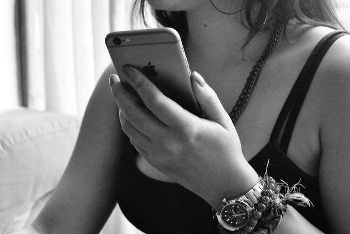 Woman holding an iPhone with a watch