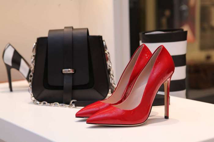 Red high heels and black handbag in a store