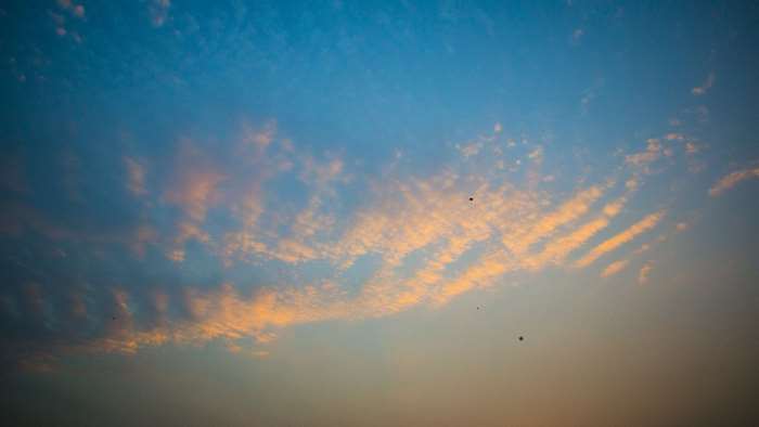 Blue sky with orange clouds and kites