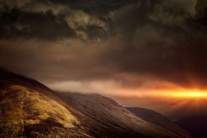 Dramatic sunset over Scottish Highlands mountains