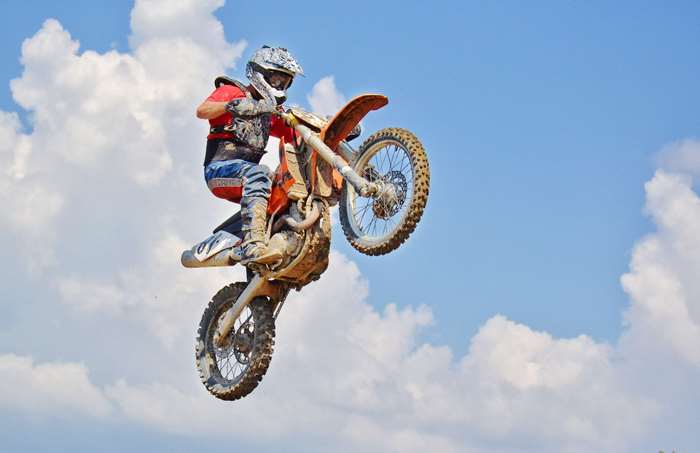 Motocross rider performing a jump on a dirt bike