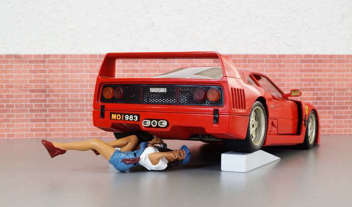 Woman working on a red Ferrari F40 model car