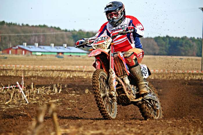 Motocross rider on a dirtbike racing on a muddy track