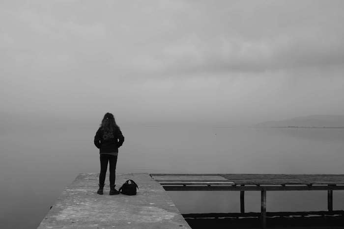 Girl standing on a dock by the lake