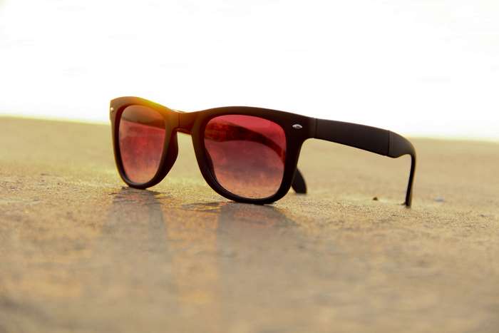 Sunglasses on sand at sunset 4K