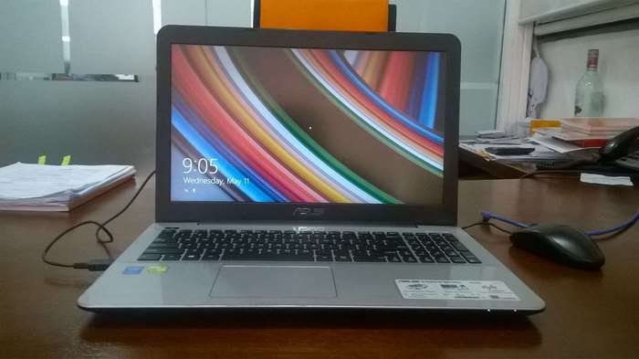 ASUS laptop with colorful wallpaper on desk