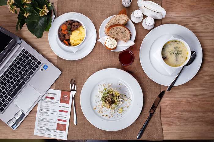 Table setting with food, laptop, and menu