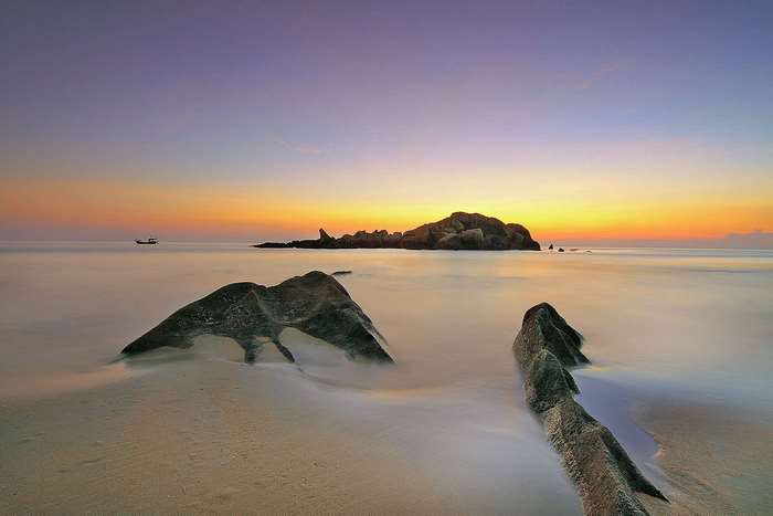 Beach rocks and ocean at sunset