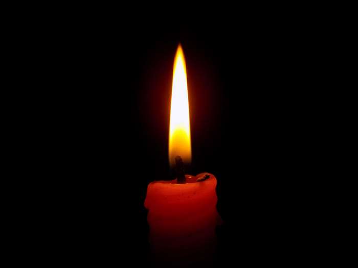 Red candle with a bright flame in the dark 4K