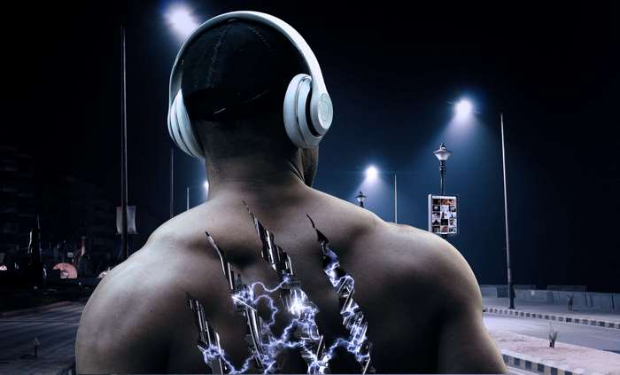 Man with headphones and metal claws on back at night