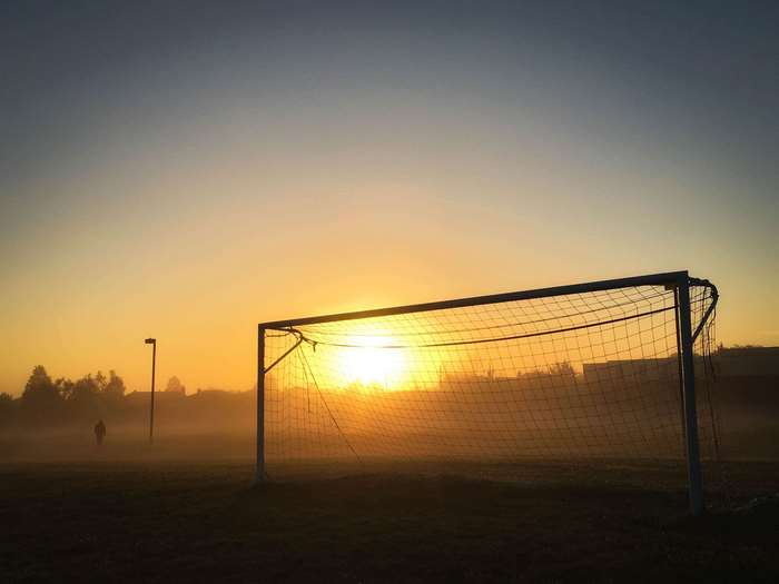 Soccer goal at sunrise with fog