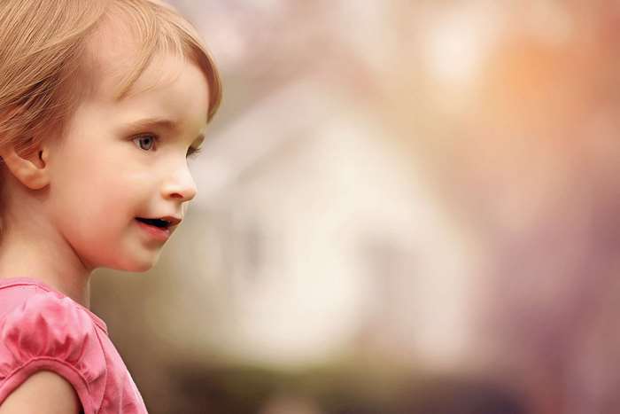 Close up side view of a young girl in a pink shirt