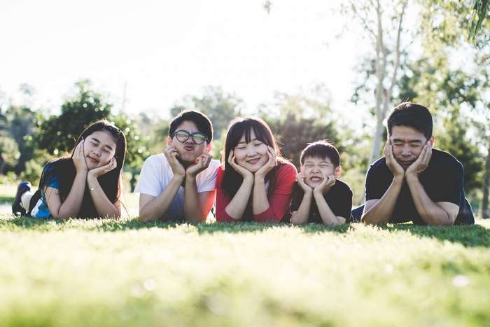 Family lying on grass in a park