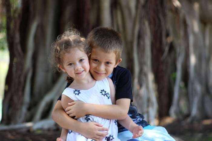 Brother hugging his sister outdoors