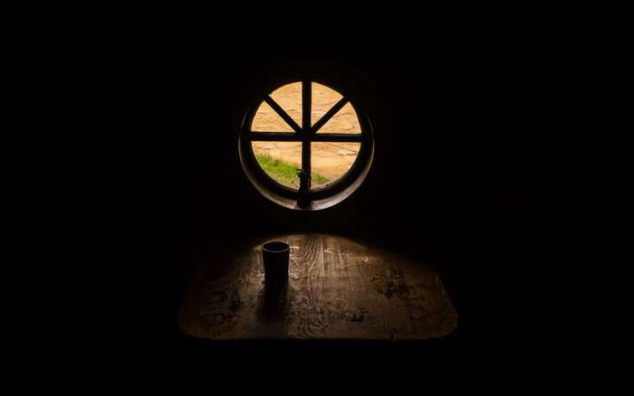 Cup on a wooden table near a round window