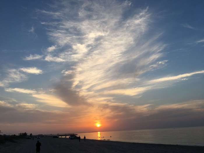 Sunset over the ocean with wispy clouds