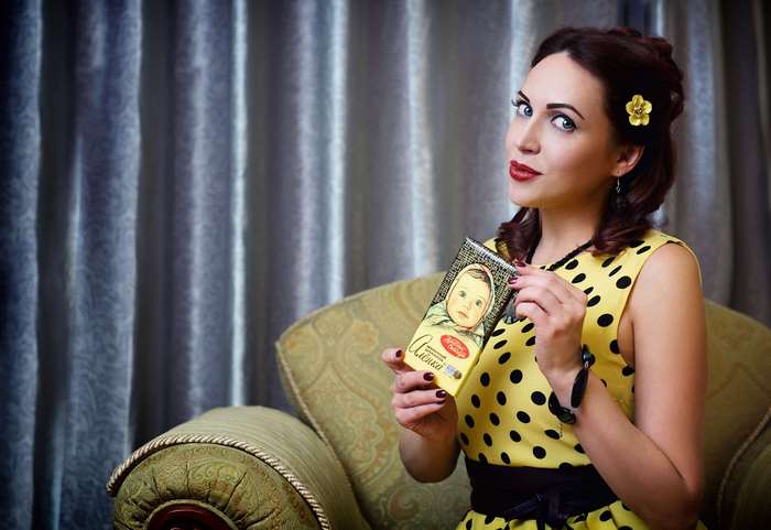 Woman in retro dress holding Alenka chocolate bar