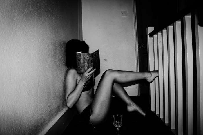 Young woman reading a book by a railing