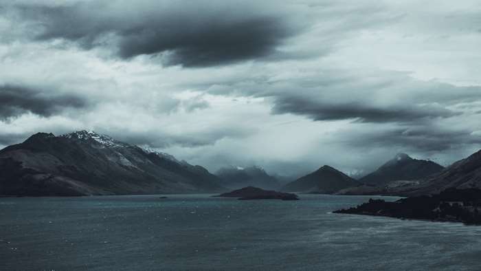 Stormy lake and mountains under cloudy sky