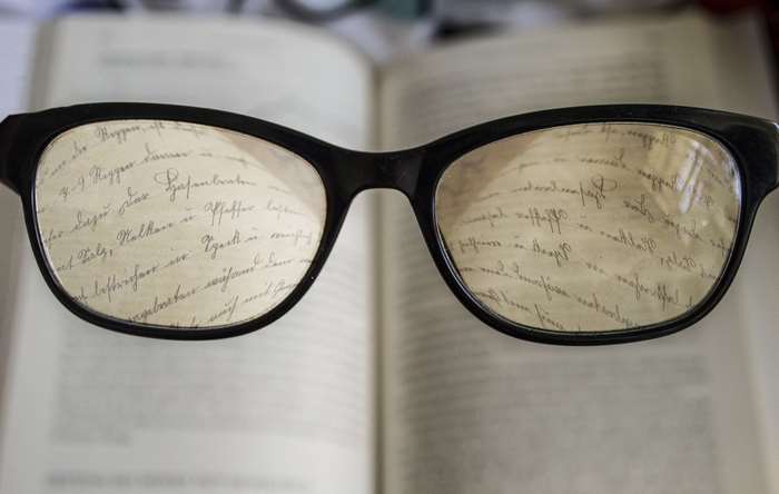 Glasses over an open book with handwritten text