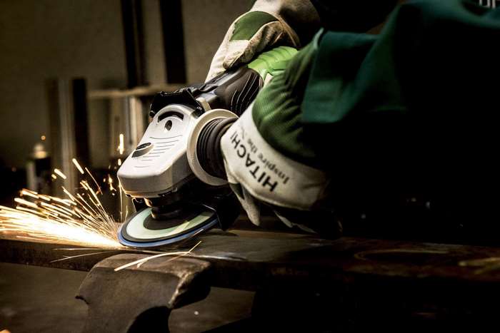 Hitachi angle grinder working on metal with sparks