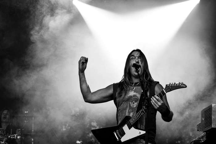 Man playing guitar on stage with smoke and lights