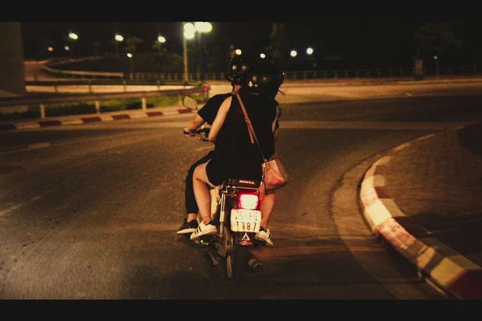 Couple riding a Honda street bike at night
