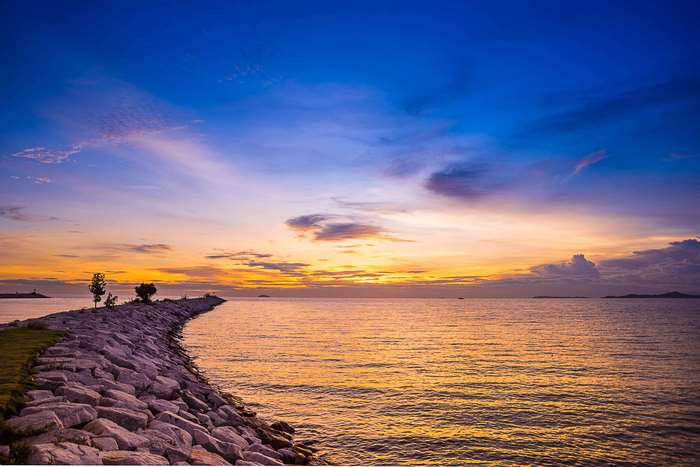 Stone jetty extending into the ocean at sunset