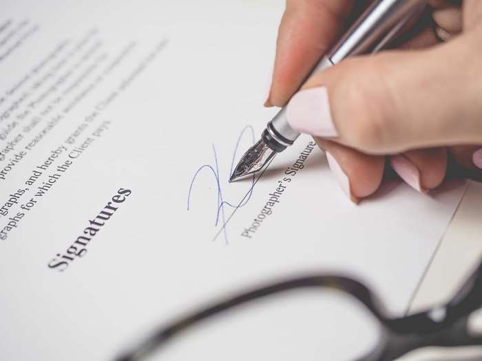Hand signing a contract with a fountain pen