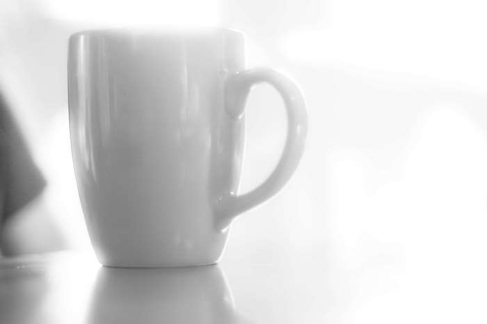Black and white high key image of a white mug