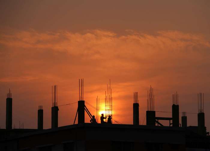 Construction site at sunset with workers