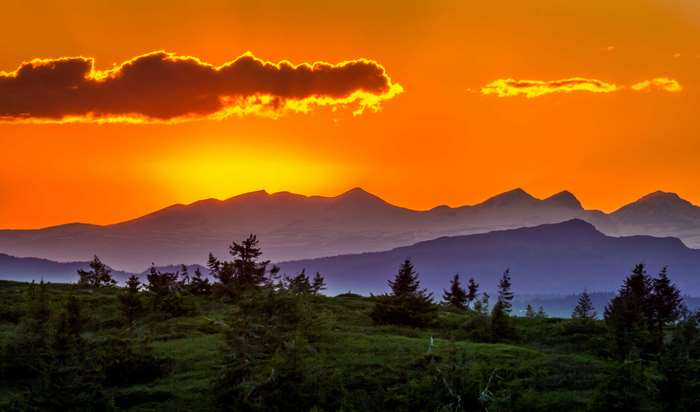 Mountain landscape at sunset with orange sky