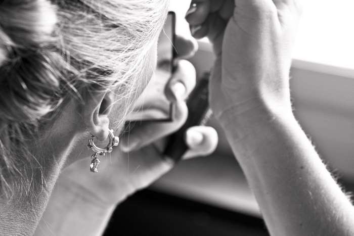 Woman applying makeup in a mirror