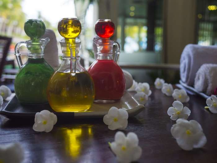 Bottles of essential oils with flowers and towels