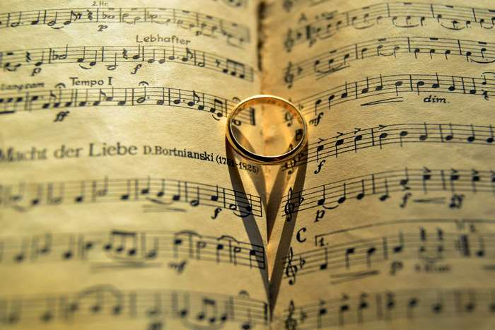 Wedding ring casting a heart shadow on sheet music