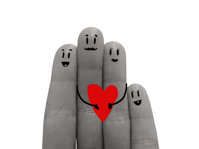 Fingers with faces holding a red heart