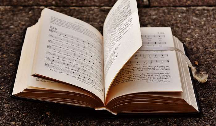 Open book with musical notes and text