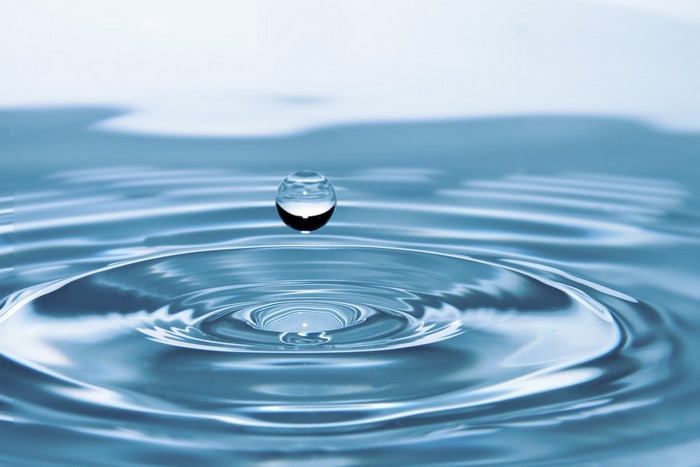 Water drop creating ripples on the surface