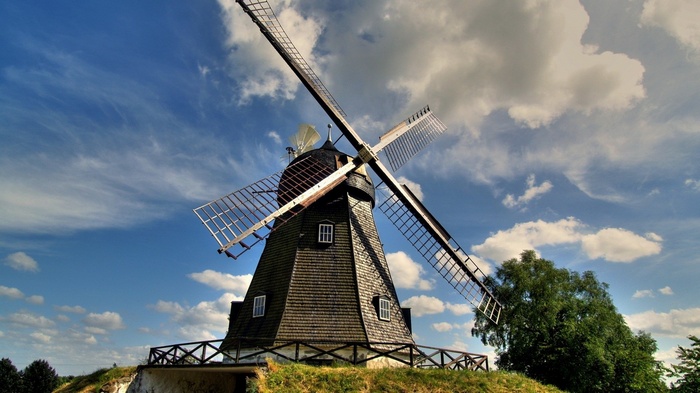 A Dutch windmill against a cloudy blue sky