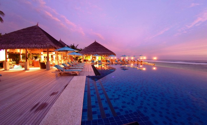 Tropical resort with infinity pool at sunset