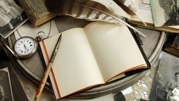 Vintage notebook, pocket watch, and quill pen